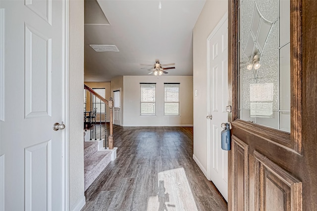 entrance foyer with visible vents, a ceiling fan, baseboards, stairs, and dark wood-style flooring