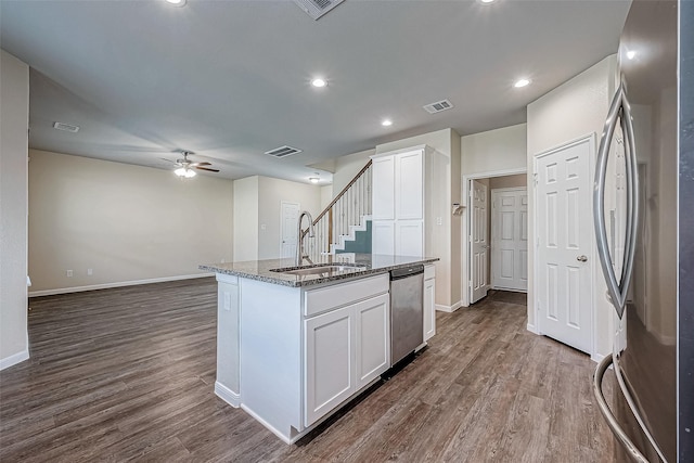 kitchen featuring stainless steel appliances, dark stone countertops, visible vents, a sink, and ceiling fan