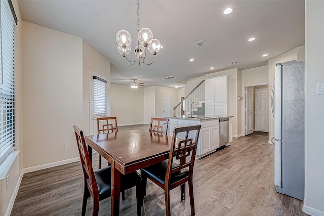 dining space with light wood-style flooring, baseboards, visible vents, an inviting chandelier, and recessed lighting