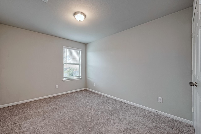 unfurnished room with baseboards and carpet