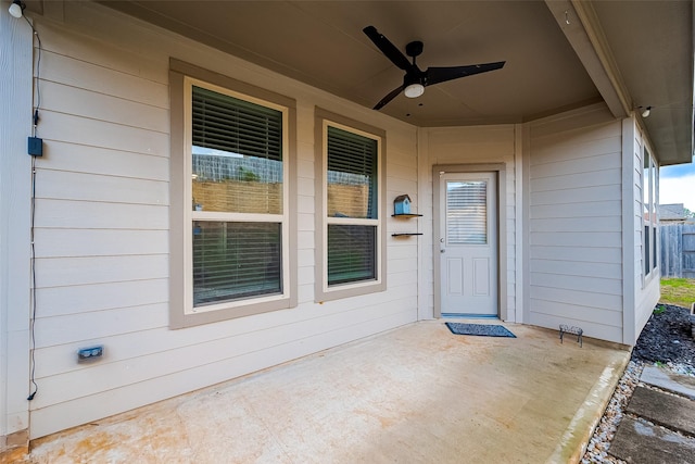 view of exterior entry with ceiling fan and covered porch