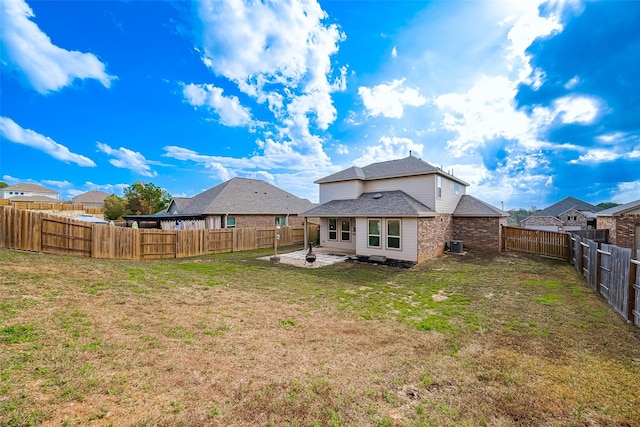 rear view of property featuring a fenced backyard, a yard, and a patio