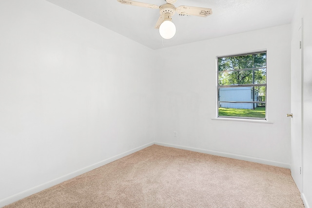 carpeted empty room featuring baseboards and ceiling fan