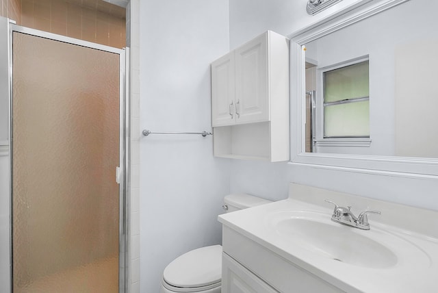 bathroom featuring vanity, toilet, and a stall shower