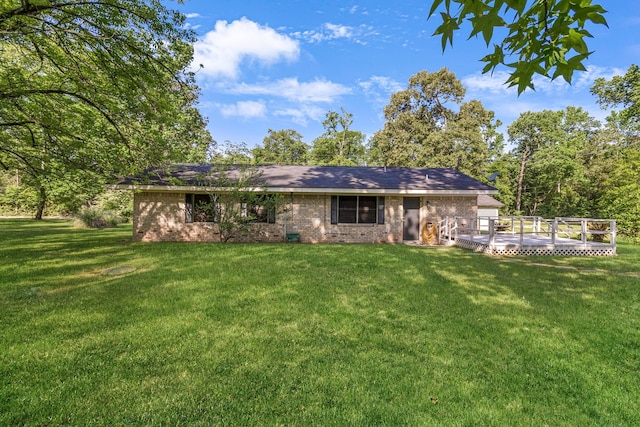 view of front of property featuring brick siding, a front yard, and a deck