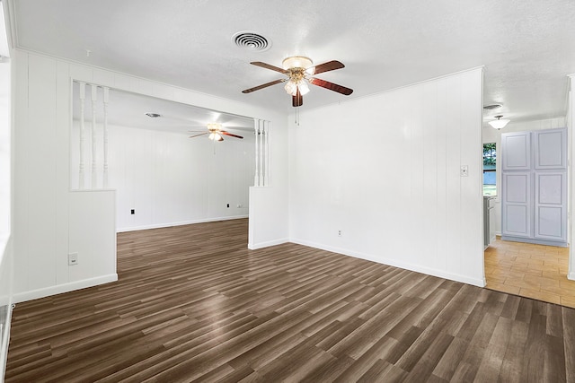 spare room with a ceiling fan, wood finished floors, a textured ceiling, baseboards, and visible vents