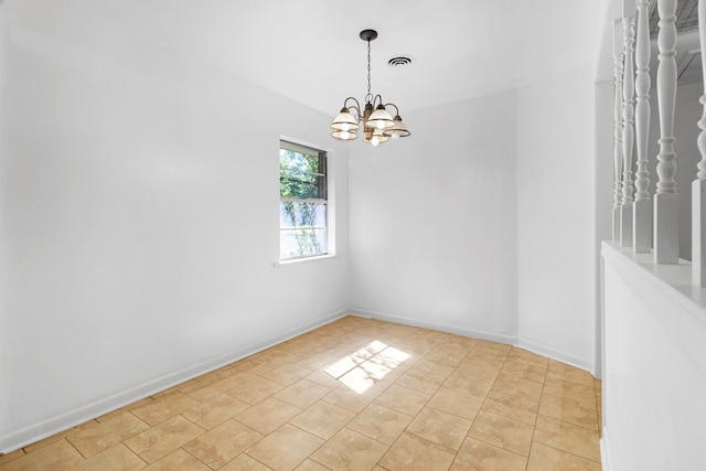 spare room with baseboards, a notable chandelier, and visible vents
