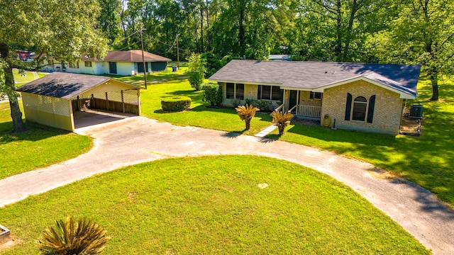 view of front of house with concrete driveway, a carport, covered porch, cooling unit, and a front yard