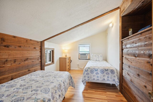 4211 San Jacinto Dr, Galveston, TX 77554 - bedroom with vaulted ceiling, a textured ceiling, cooling unit, and wood finished floors