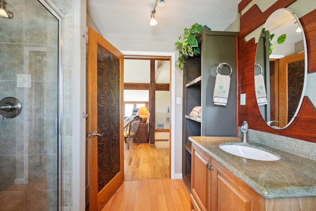 4211 San Jacinto Dr, Galveston, TX 77554 - bathroom with a tile shower, vanity, and wood finished floors