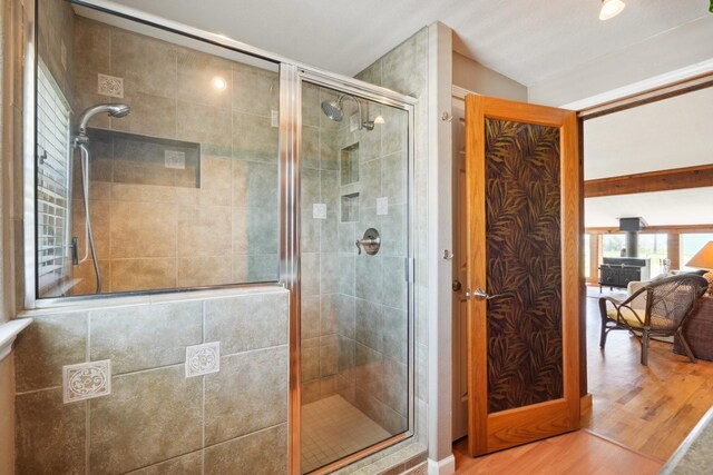 4211 San Jacinto Dr, Galveston, TX 77554 - bathroom with vaulted ceiling, wood finished floors, and a stall shower