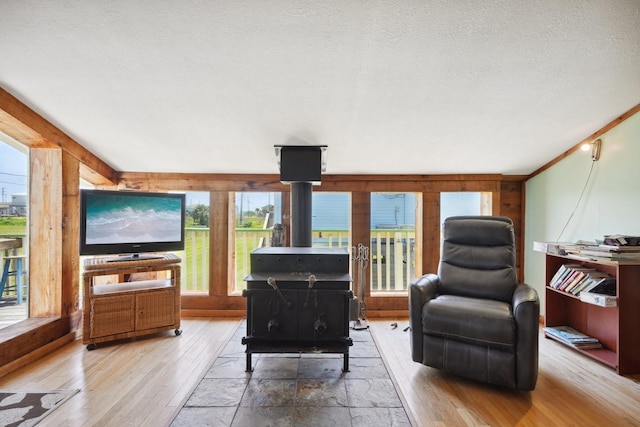 4211 San Jacinto Dr, Galveston, TX 77554 - living area with hardwood / wood-style flooring, a wood stove, and a textured ceiling
