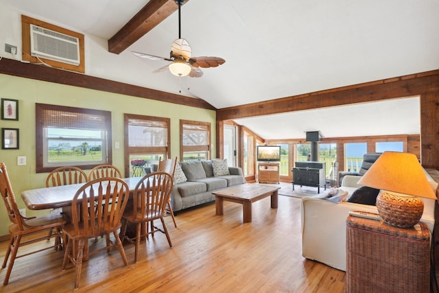 4211 San Jacinto Dr, Galveston, TX 77554 - living room with a wood stove, vaulted ceiling with beams, a wall unit AC, light wood-style floors, and ceiling fan