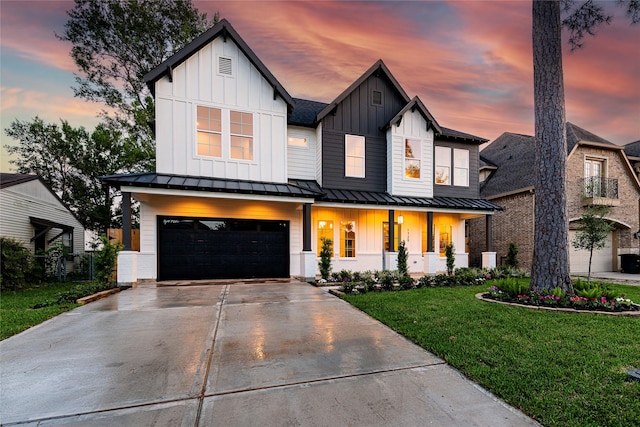 modern inspired farmhouse with board and batten siding, a front lawn, covered porch, and a garage