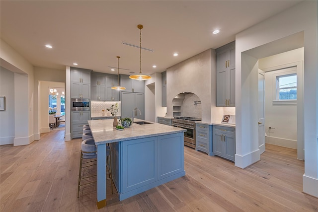 kitchen with stainless steel appliances, visible vents, baseboards, decorative backsplash, and light wood-style flooring