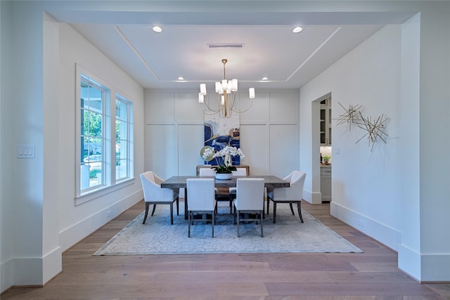 dining space with baseboards, an inviting chandelier, wood finished floors, and recessed lighting