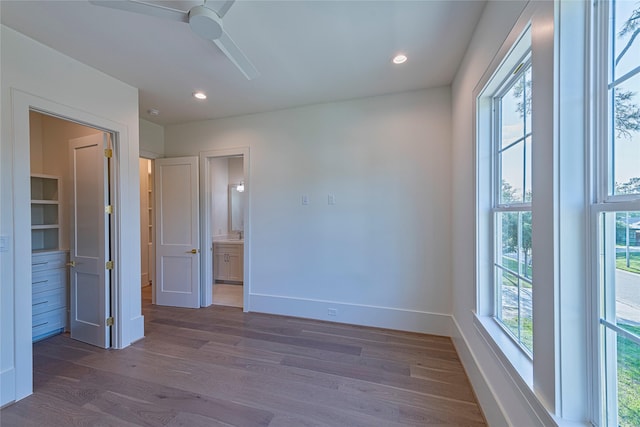 unfurnished bedroom featuring recessed lighting, ensuite bath, baseboards, and dark wood-style flooring