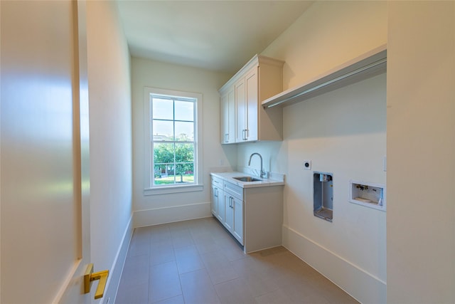 washroom with hookup for a washing machine, a sink, electric dryer hookup, cabinet space, and baseboards