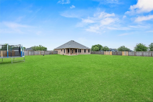 view of yard with a fenced backyard and a trampoline