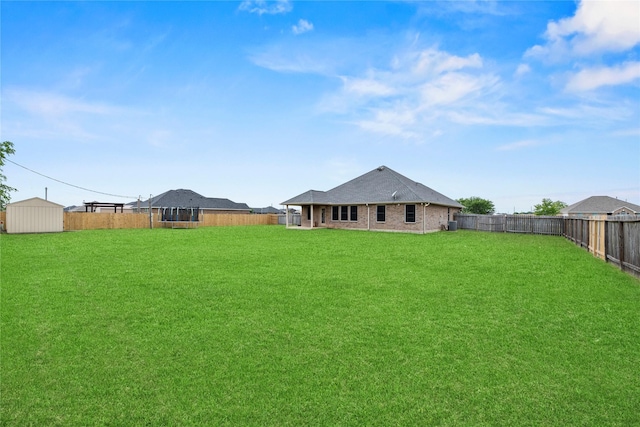 view of yard featuring an outdoor structure, a shed, and a fenced backyard