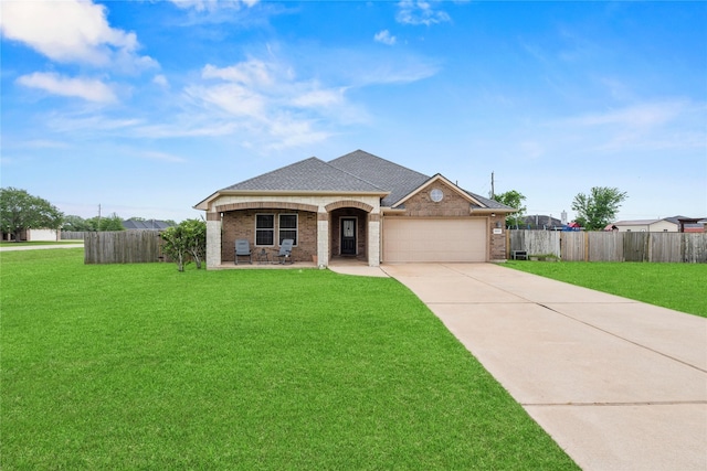 view of front of home featuring a garage, fence, a front yard, and concrete driveway