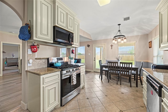 kitchen with light stone countertops, visible vents, appliances with stainless steel finishes, and cream cabinets