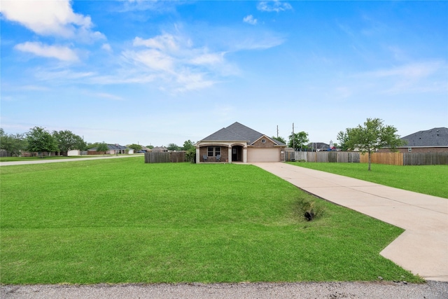 view of front of home featuring a front lawn, fence, driveway, and an attached garage