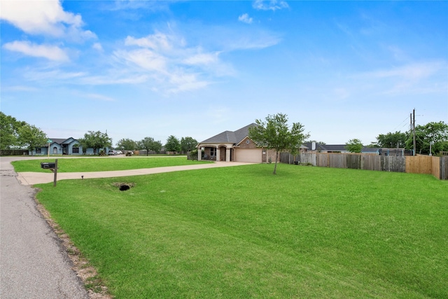 ranch-style home featuring fence, concrete driveway, a front lawn, and a garage