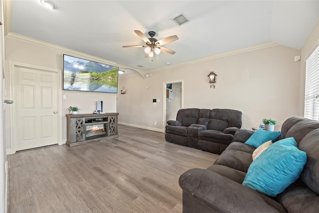 living room with wood finished floors, visible vents, ceiling fan, and crown molding