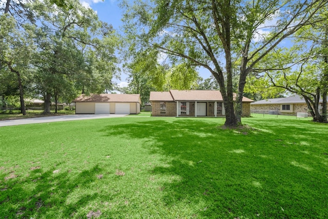 ranch-style house with fence, an outbuilding, a detached garage, and a front yard