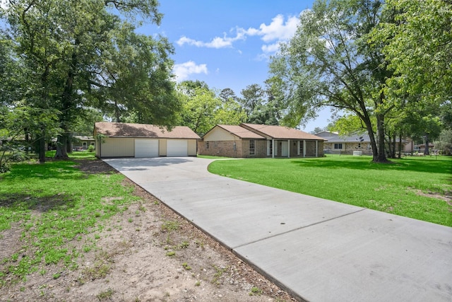 single story home with an outdoor structure, a detached garage, driveway, and a front yard