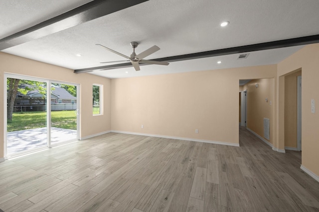 spare room featuring beam ceiling, light wood finished floors, baseboards, and ceiling fan