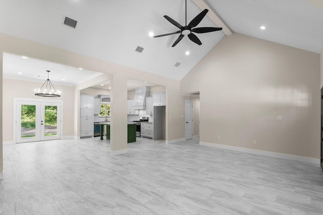 unfurnished living room with visible vents, high vaulted ceiling, french doors, and ceiling fan with notable chandelier