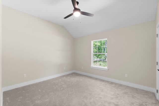 unfurnished room with vaulted ceiling, baseboards, carpet floors, and a ceiling fan