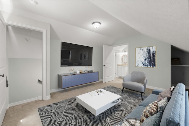 carpeted living area featuring lofted ceiling and baseboards