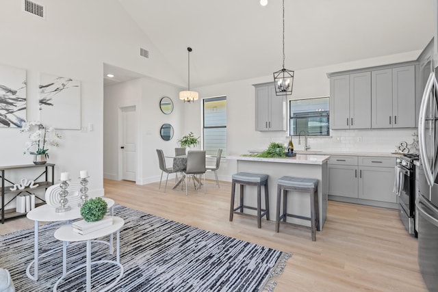 kitchen with gray cabinets, gas range, and visible vents
