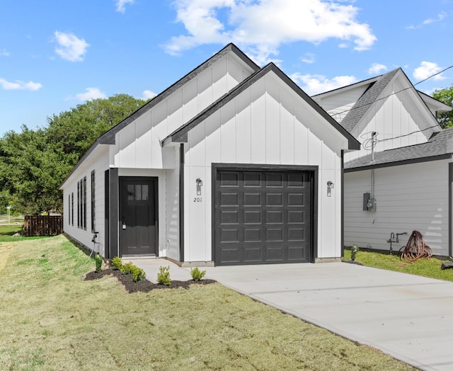 modern farmhouse featuring a front lawn, driveway, board and batten siding, a shingled roof, and a garage