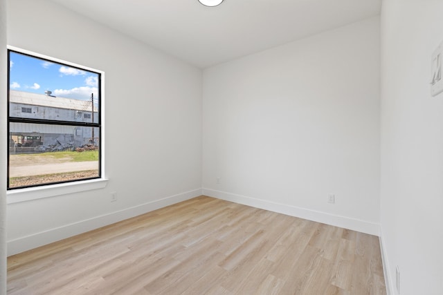 unfurnished room with baseboards and wood finished floors