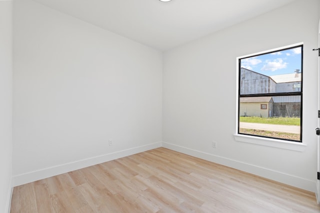 empty room featuring wood finished floors and baseboards