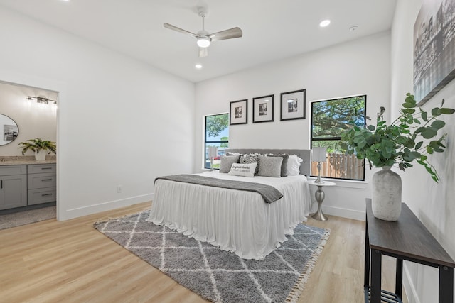 bedroom featuring baseboards, recessed lighting, ensuite bathroom, and light wood-style flooring