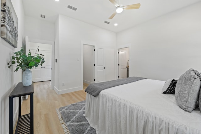 bedroom with a high ceiling, baseboards, visible vents, and light wood-type flooring