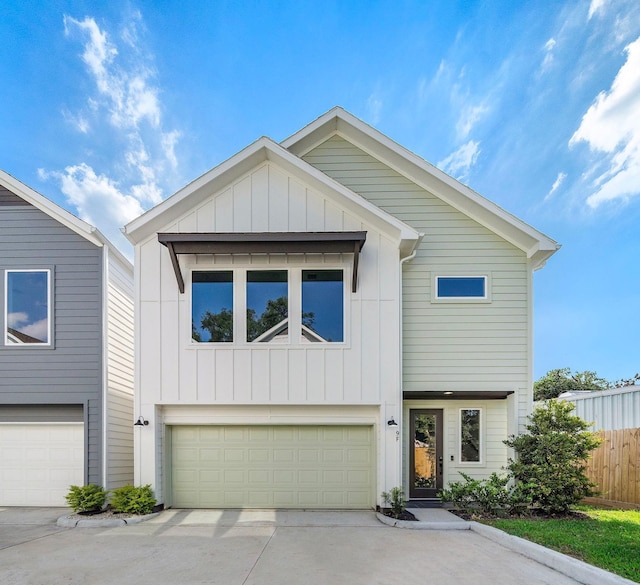 view of front of home featuring concrete driveway, an attached garage, fence, and board and batten siding