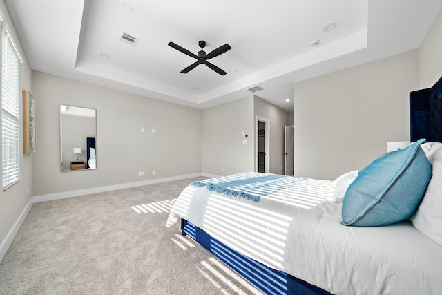 bedroom with ceiling fan, baseboards, carpet, and a raised ceiling