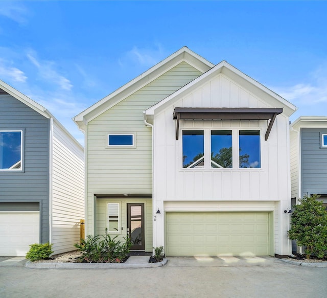 view of front facade with concrete driveway, an attached garage, and board and batten siding