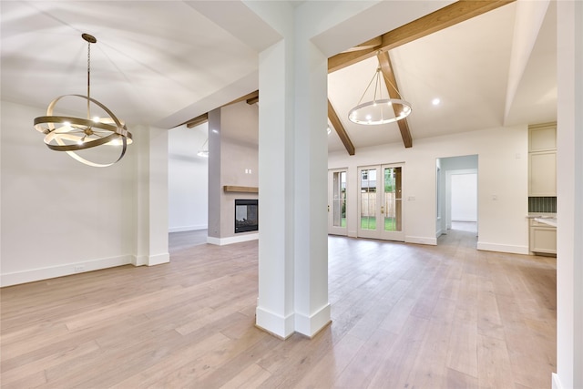 unfurnished living room featuring light wood-type flooring, vaulted ceiling with beams, a chandelier, and a fireplace