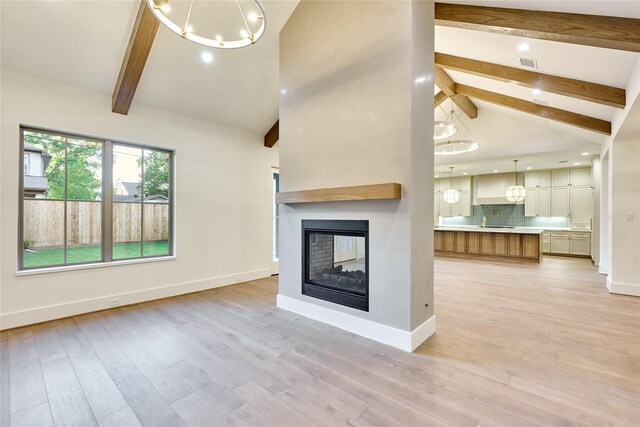unfurnished living room with beamed ceiling, visible vents, and baseboards