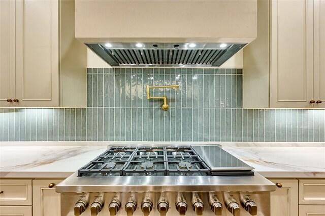 1570 Cheshire Ln, Houston, TX 77018 - kitchen view of ventilation hood, light stone countertops, tasteful backsplash, pot filler, and gas cooktop