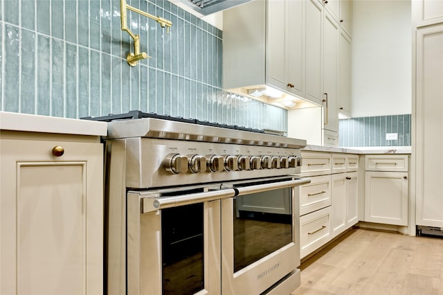 1570 Cheshire Ln, Houston, TX 77018 - kitchen with range with two ovens, tasteful backsplash, light wood finished floors, white cabinetry, and light countertops