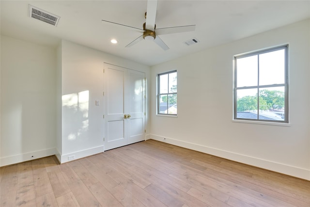 unfurnished bedroom featuring baseboards, visible vents, and light wood-style floors