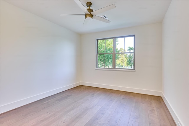 empty room with baseboards, visible vents, a ceiling fan, and light wood-style floors